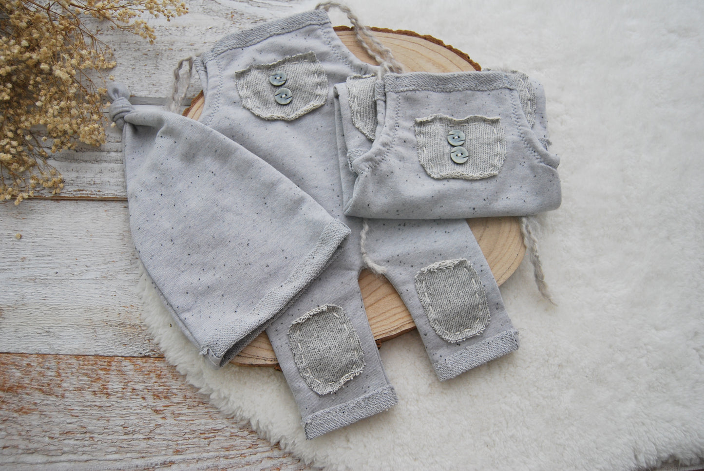 Gray baby pants with patches on a wooden surface
