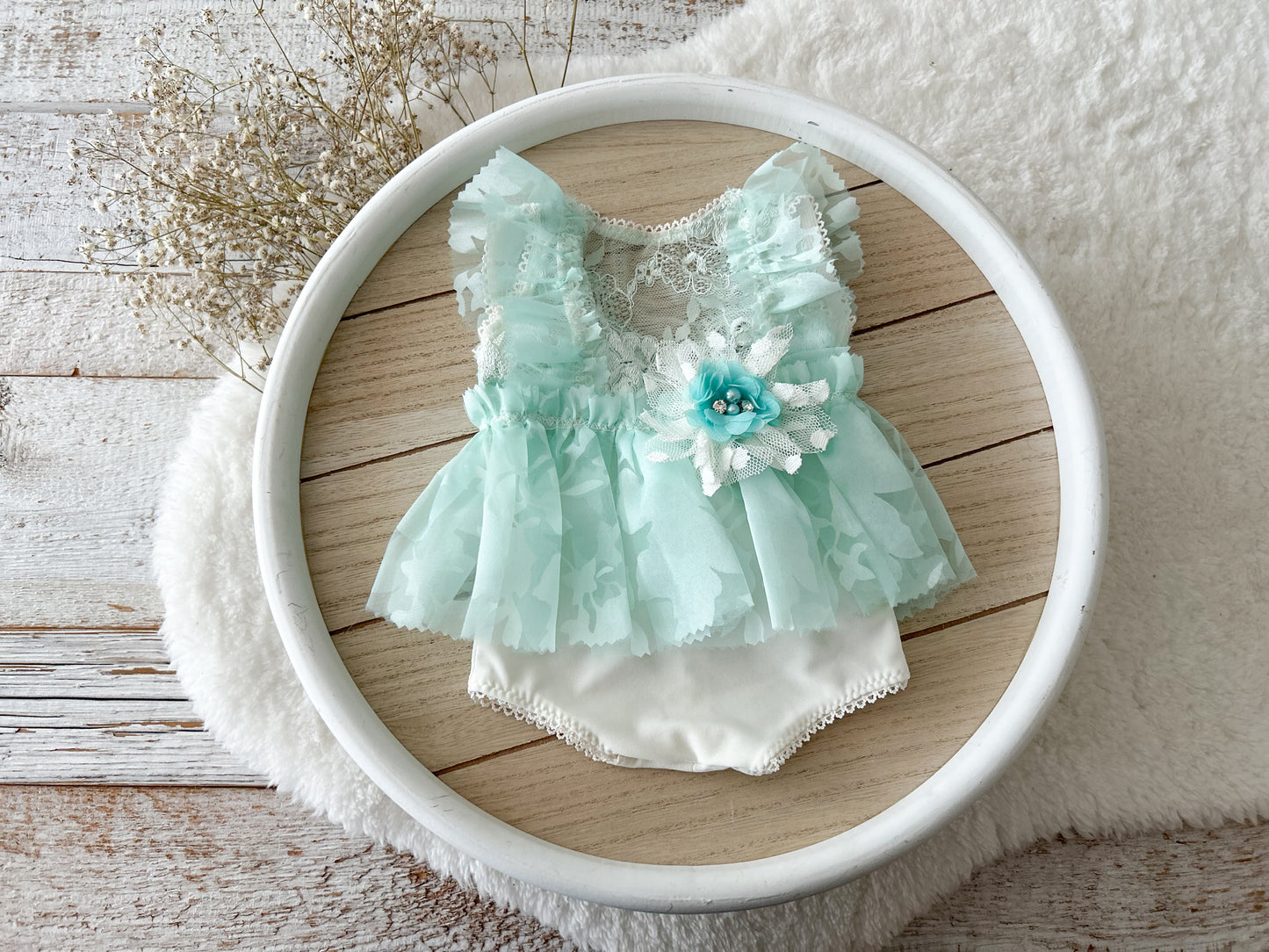Newborn girl photo outfit in Light mint color floral details on a wooden surface