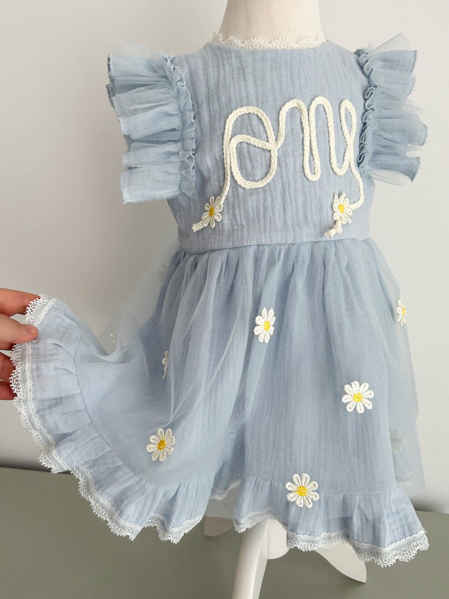 Light blue dress with floral embroidery on a mannequin against a neutral background