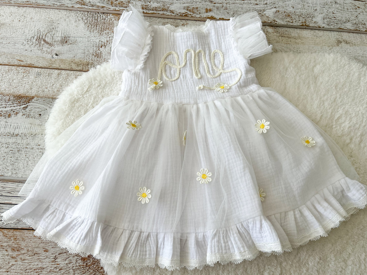 White dress with floral details on a wooden surface