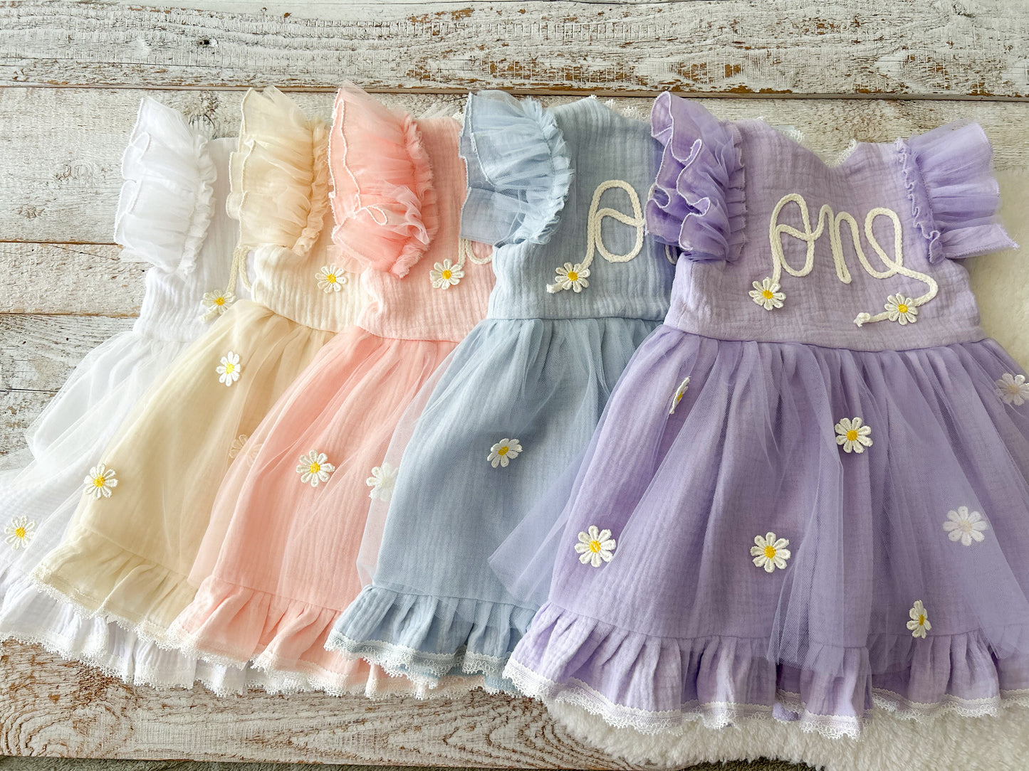 Baby girl first birthday dress with “one” embroidered on front, pastel daisy tulle