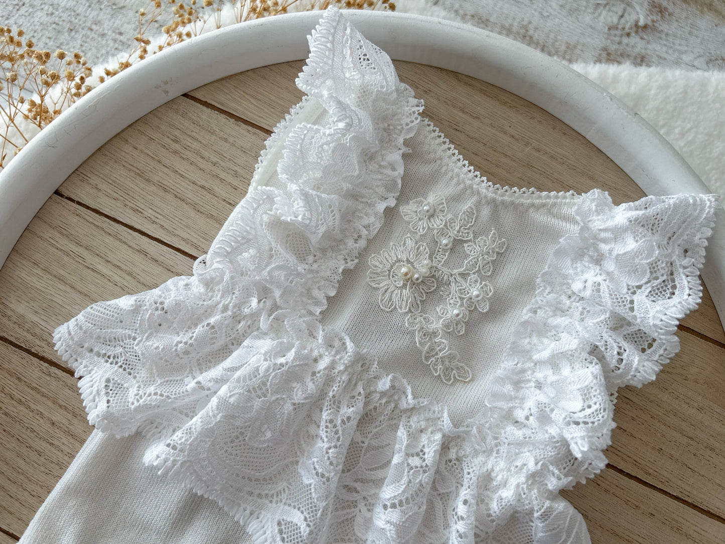 Close-up of embroidered floral lace and pearl bead detail on front panel
