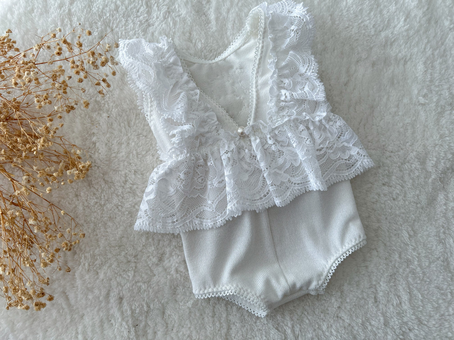 All white ruffled romper for newborn photo shoots