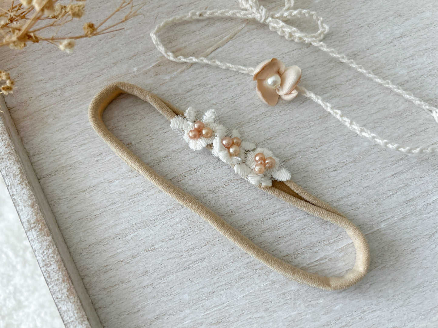 Set of two newborn photo prop headbands: one stretchy floral headband and one adjustable tie-back with pearl flower.