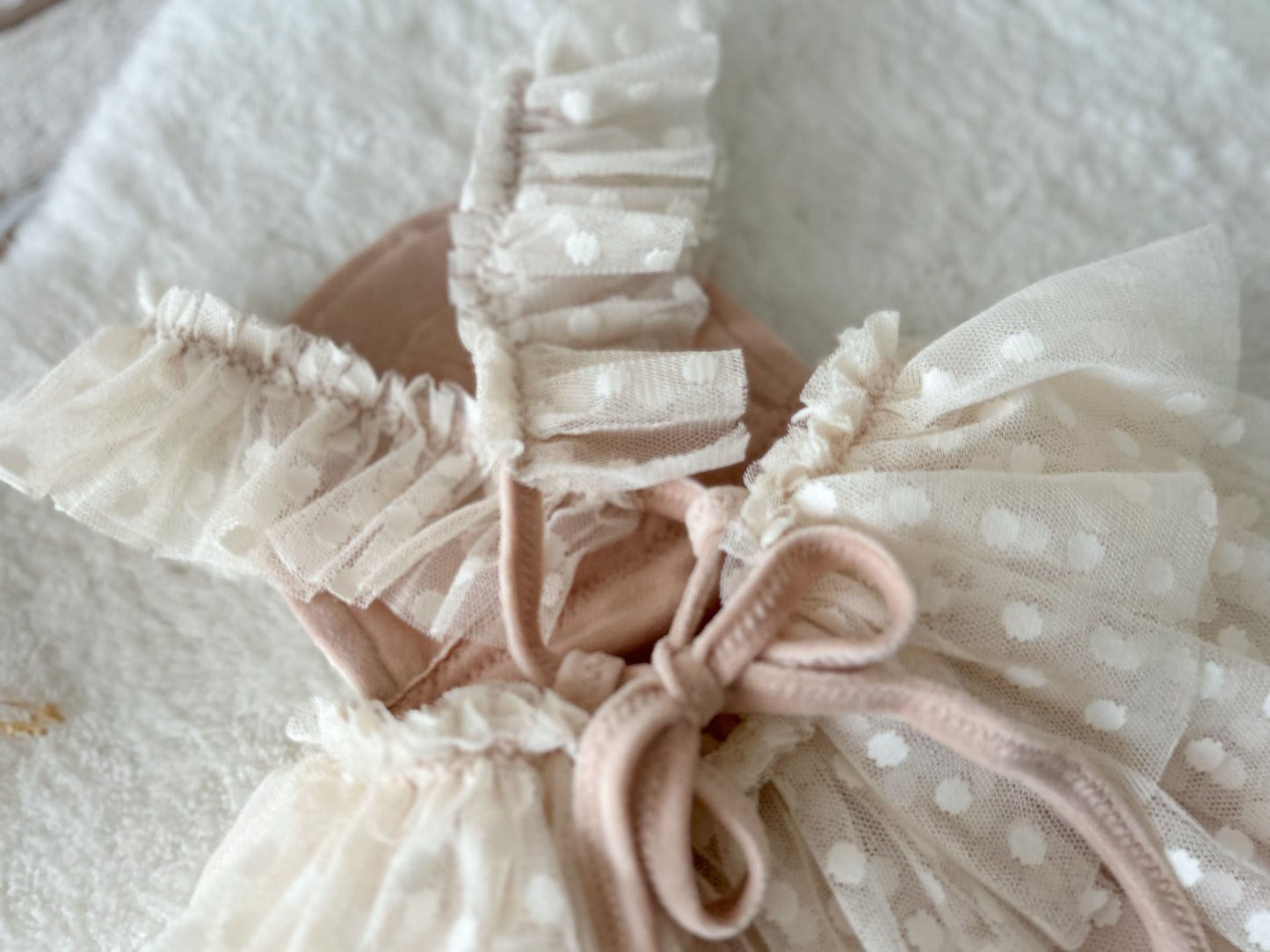 Baby girl photo prop sitter with ruffled straps criss crossed on the back
