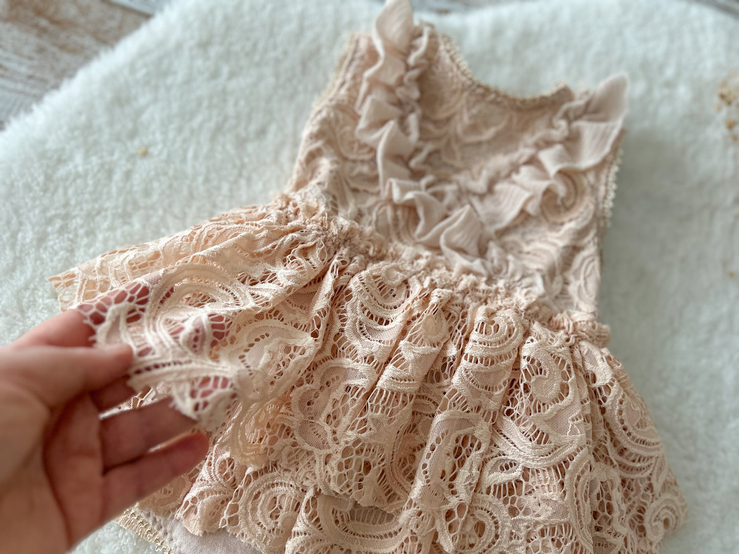 Close-up of lace and angora fabric on baby girl romper for milestone photoshoots