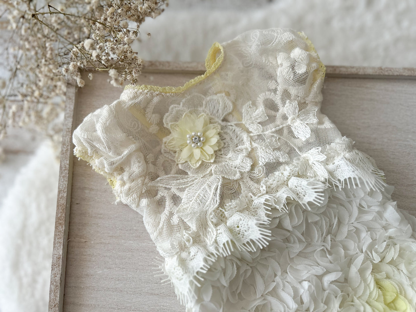 White lace garment with floral details on a wooden surface
