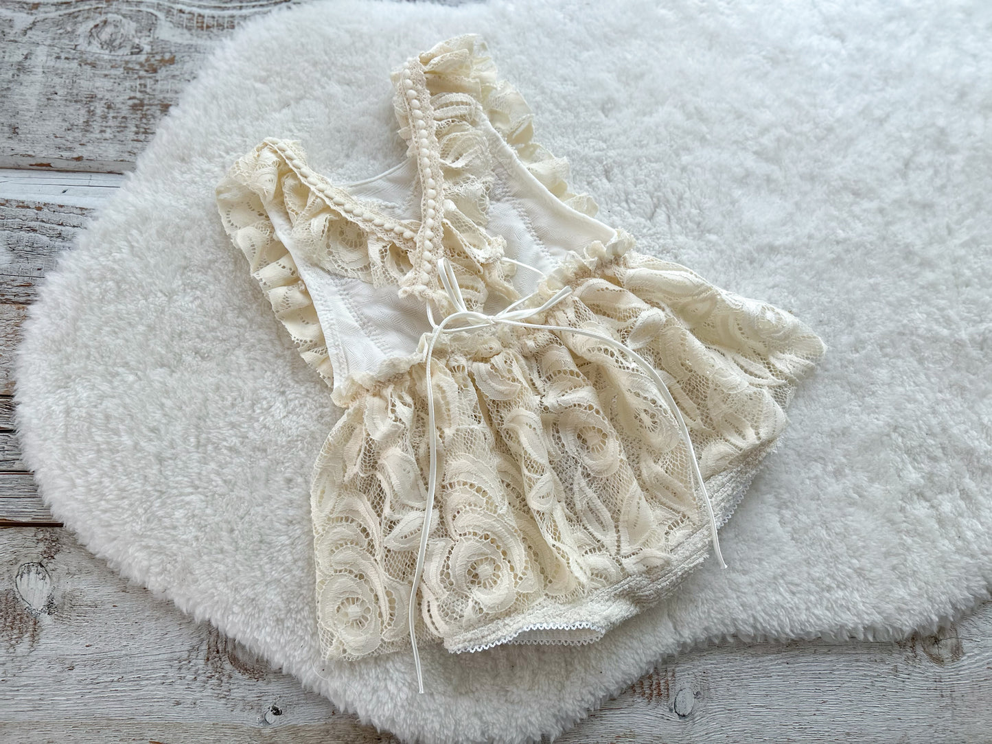 Full view of 6–12 months baby girl romper with ruffles and floral lace skirt, styled for cake smash shoots