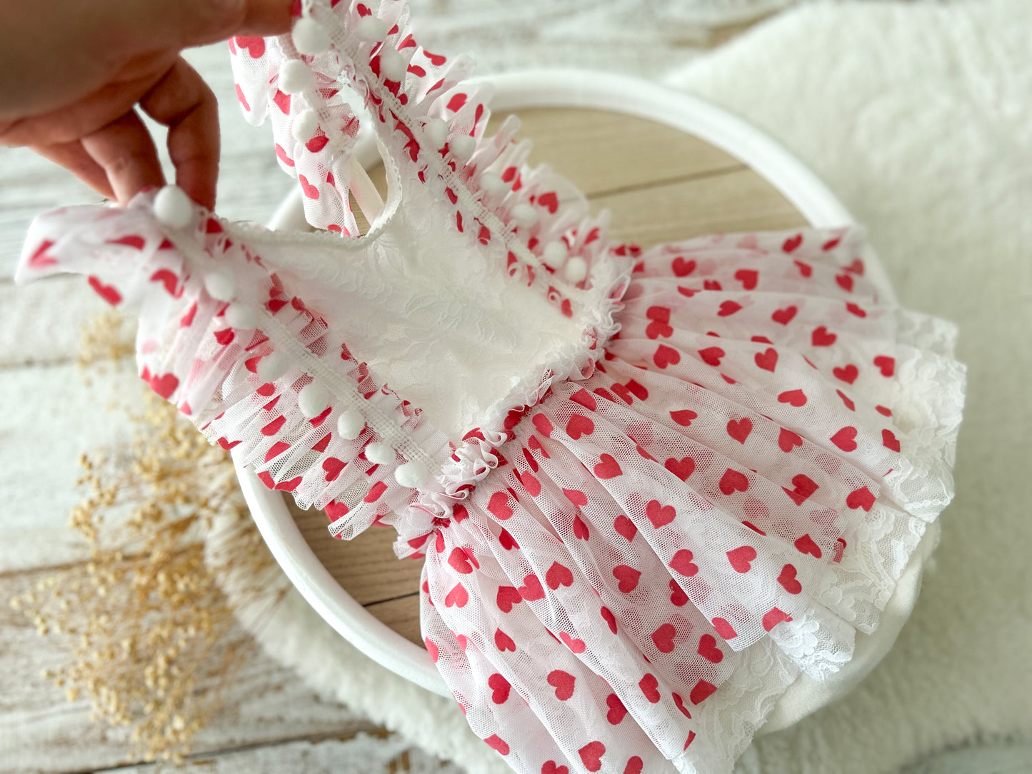 White headband with red heart patterns on a light wooden surface