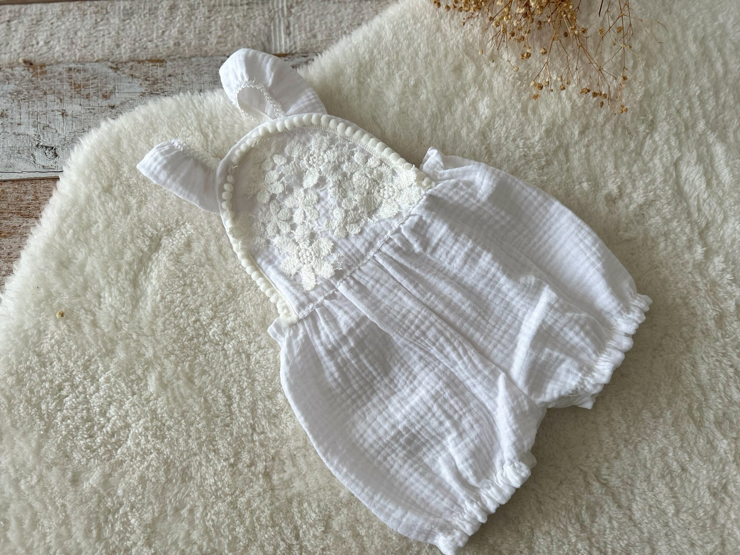 Full view of white baby photo prop romper with soft cotton texture