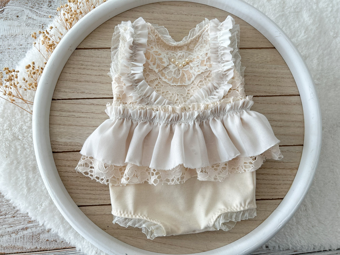 Detailed view of lace shoulder ruffles and V-back with pearl button