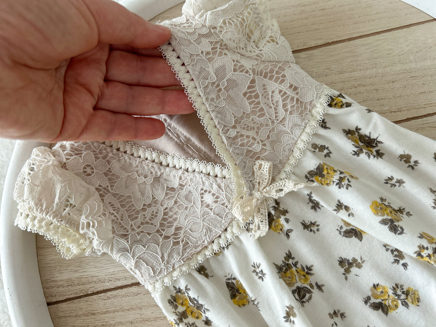 Open-back detail of newborn romper with scalloped lace trim – functional view