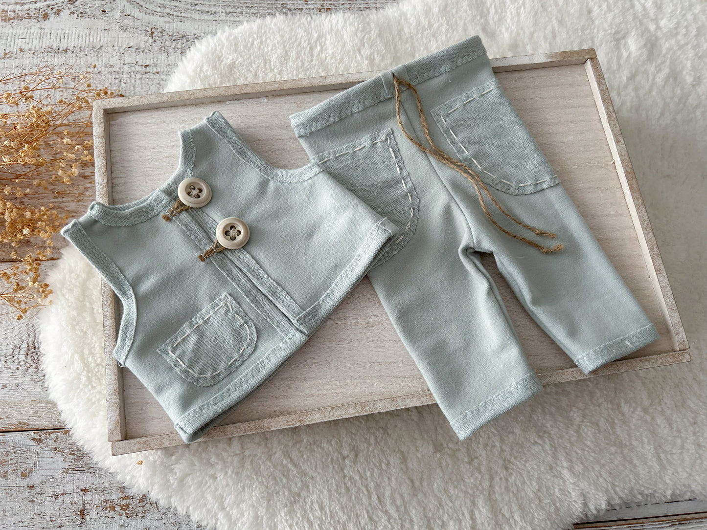 Duck egg blue newborn vest and pants on wooden tray.