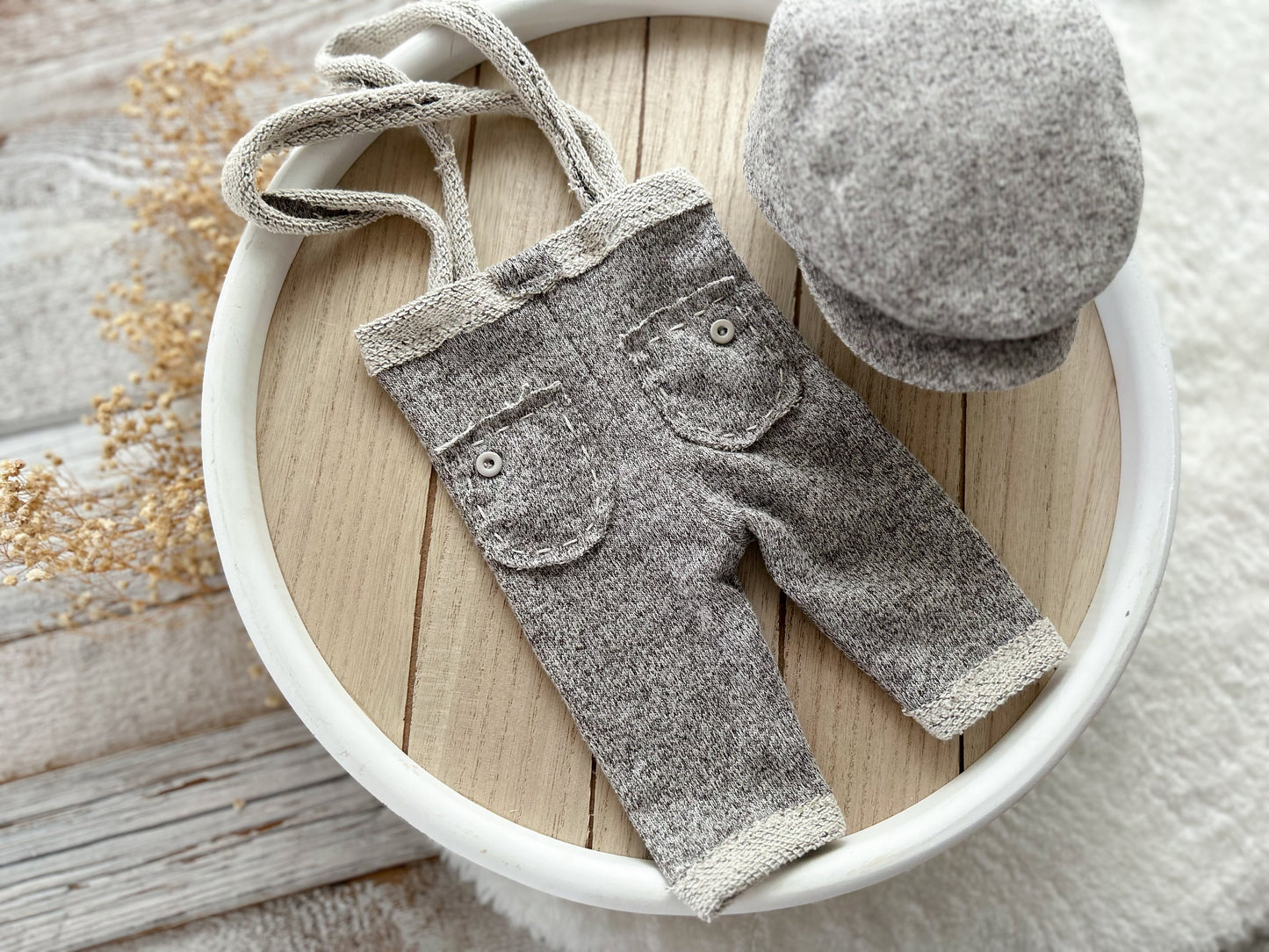 Gray baby pants and hat set on a wooden surface