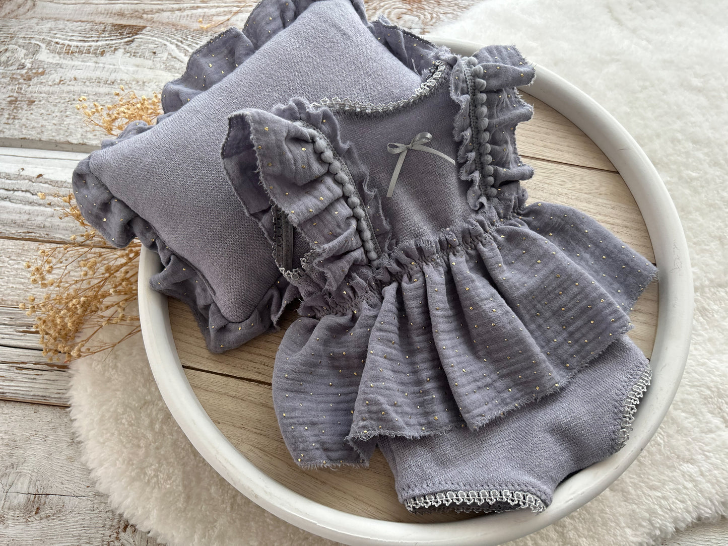 Newborn photography prop set in dusty lavender, featuring a ruffled romper with bow detail and a matching filled pillow with ruffled trim, styled for baby girl photo shoots.