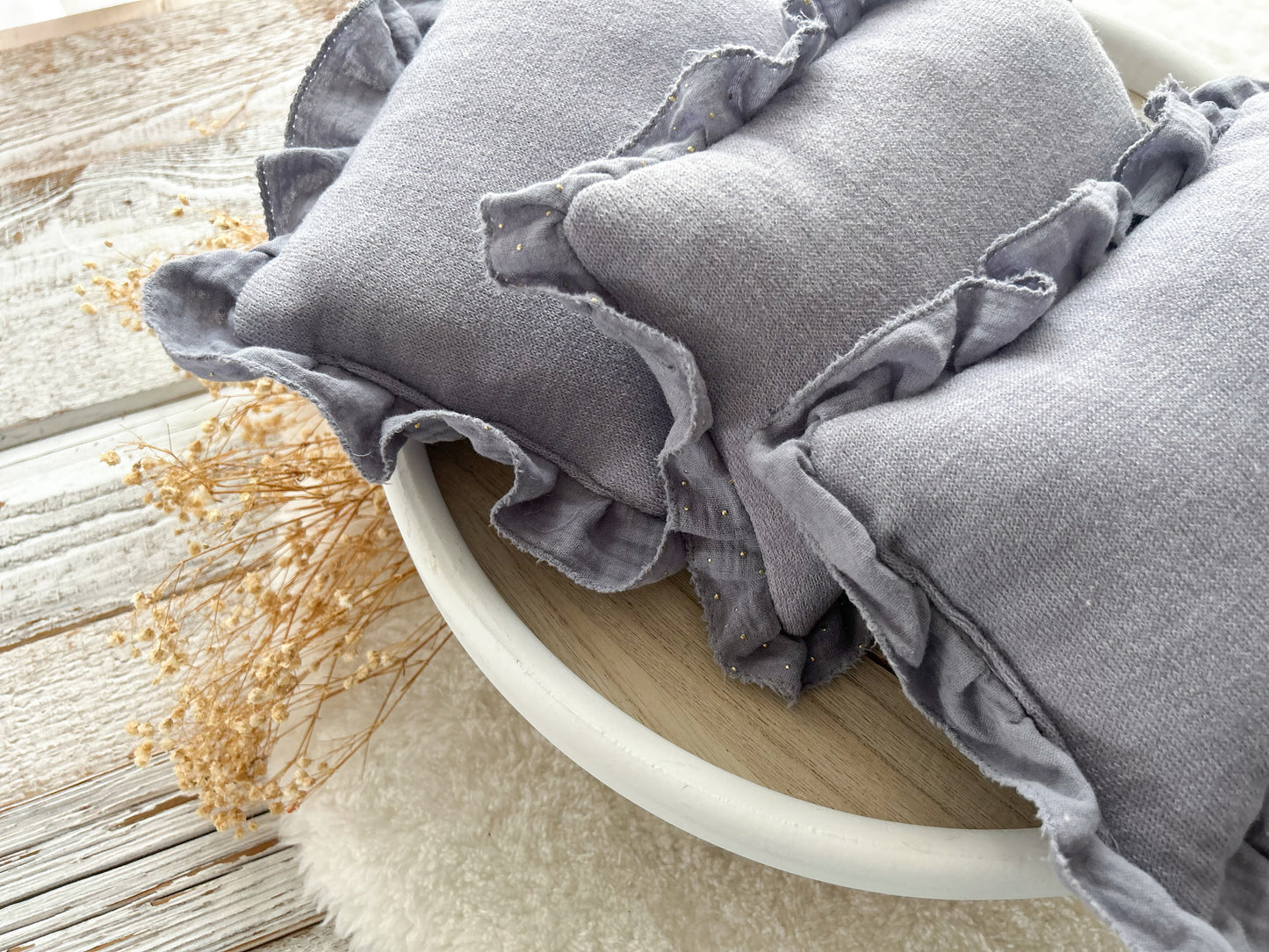 Close-up on newborn posing pillow with ruffles