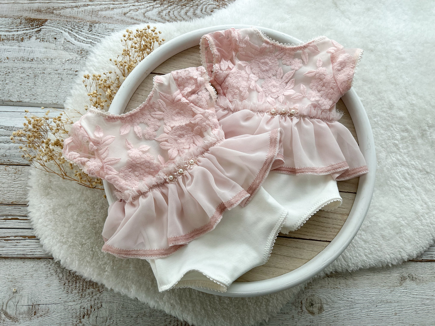 Front and back view of white and pink newborn romper with floral lace bodice and V-cut back.