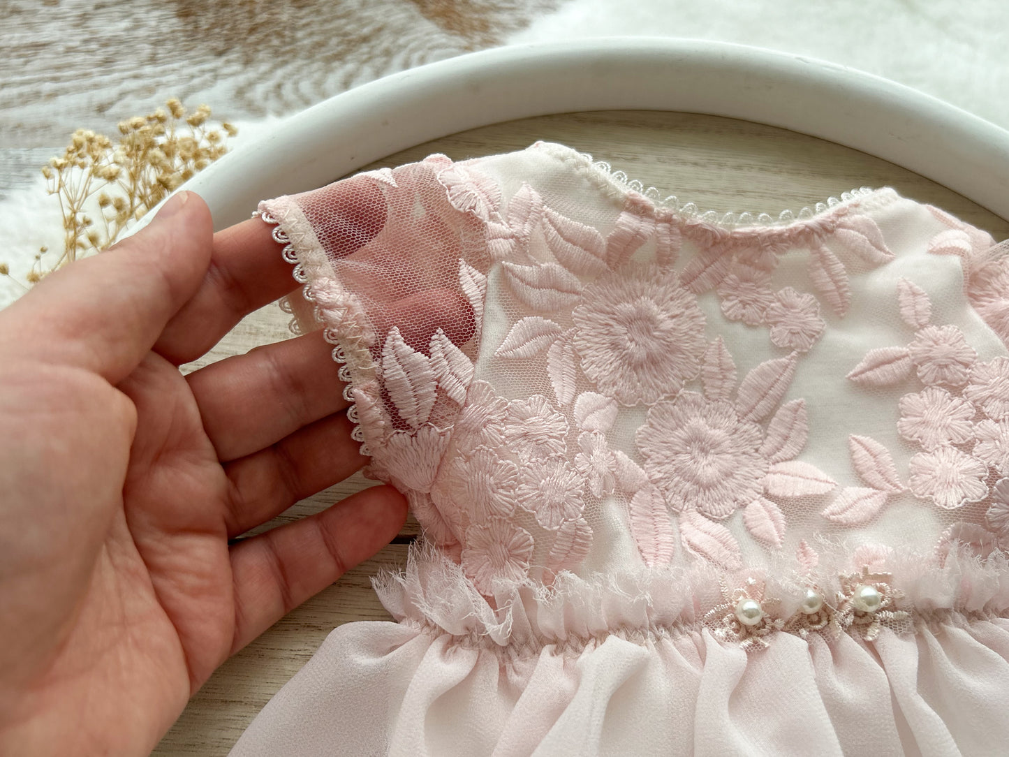 Close up on short lace sleeves of a newborn photo outfit