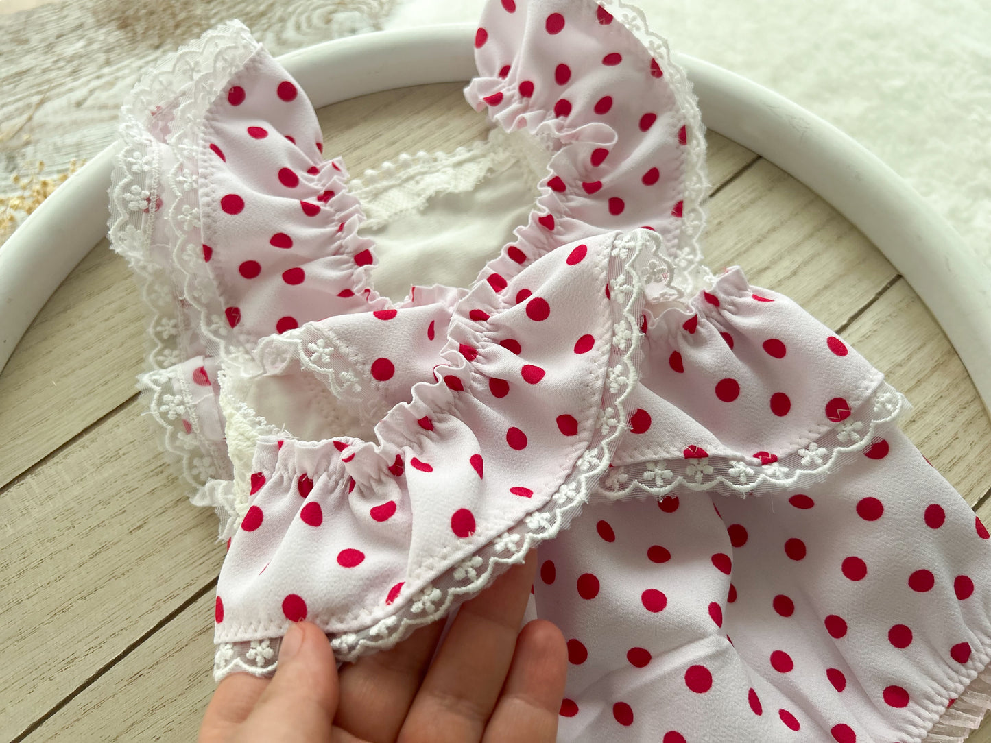The back of newborn girl romper light pink color bright pink polka dots