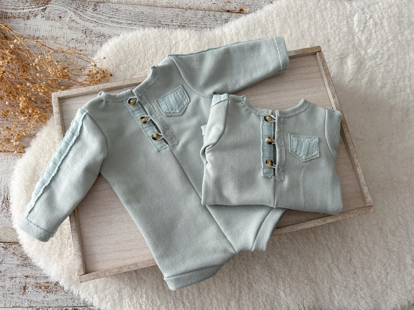 Duck egg blue newborn romper with matching sleepy hat on soft cream background