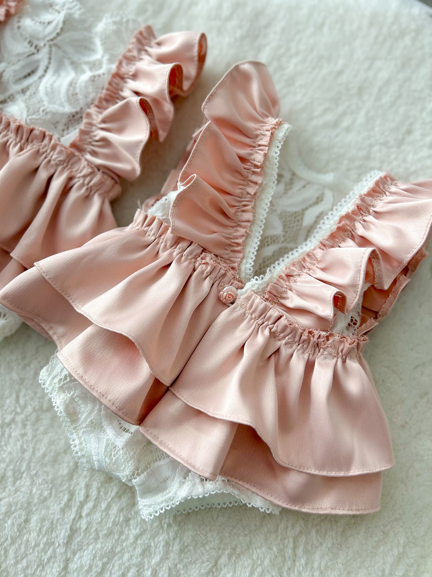 Newborn lace romper with pink satin ruffles and floral lace front