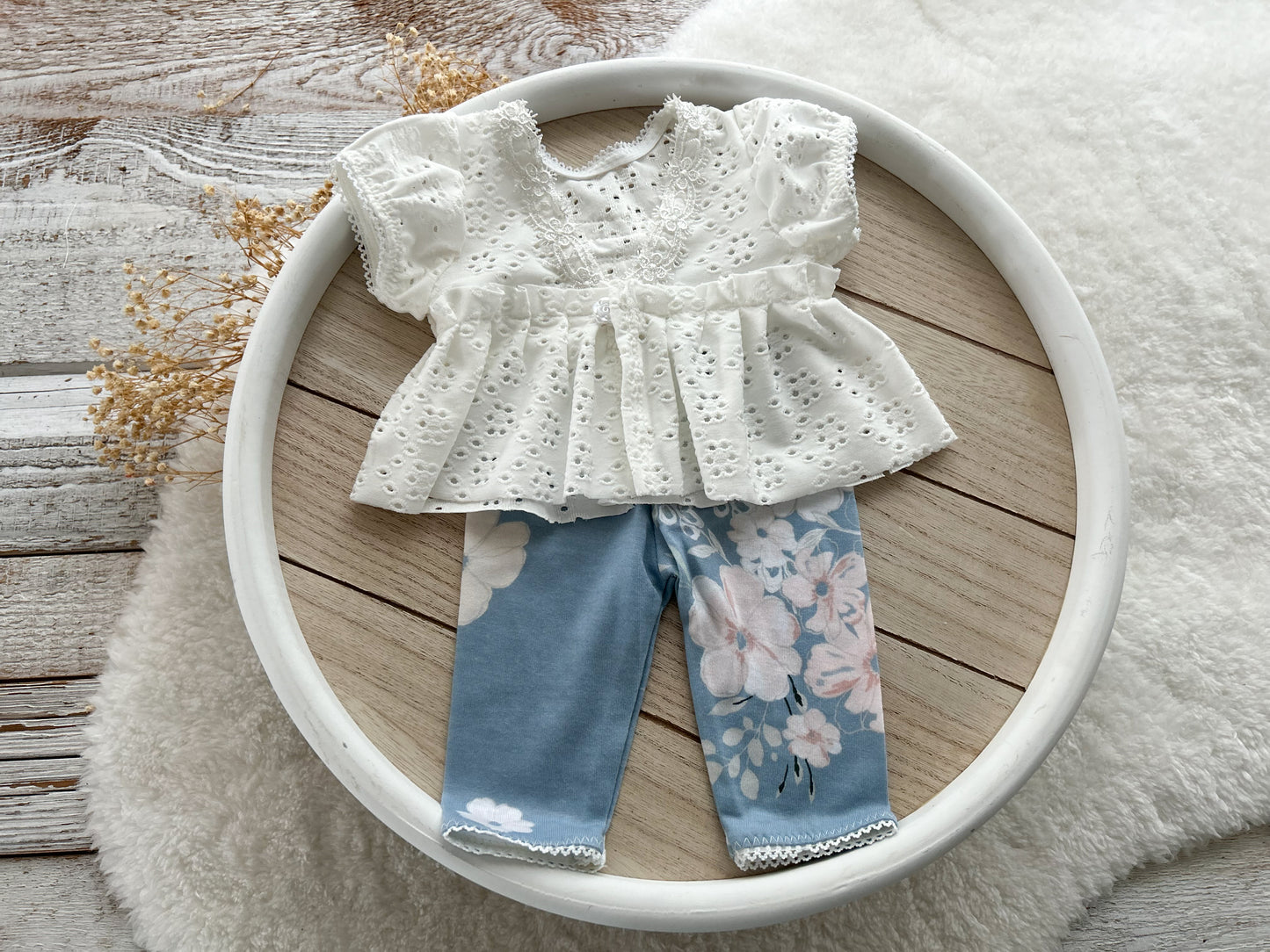 White blouse with floral pants on a white plate on a wooden surface