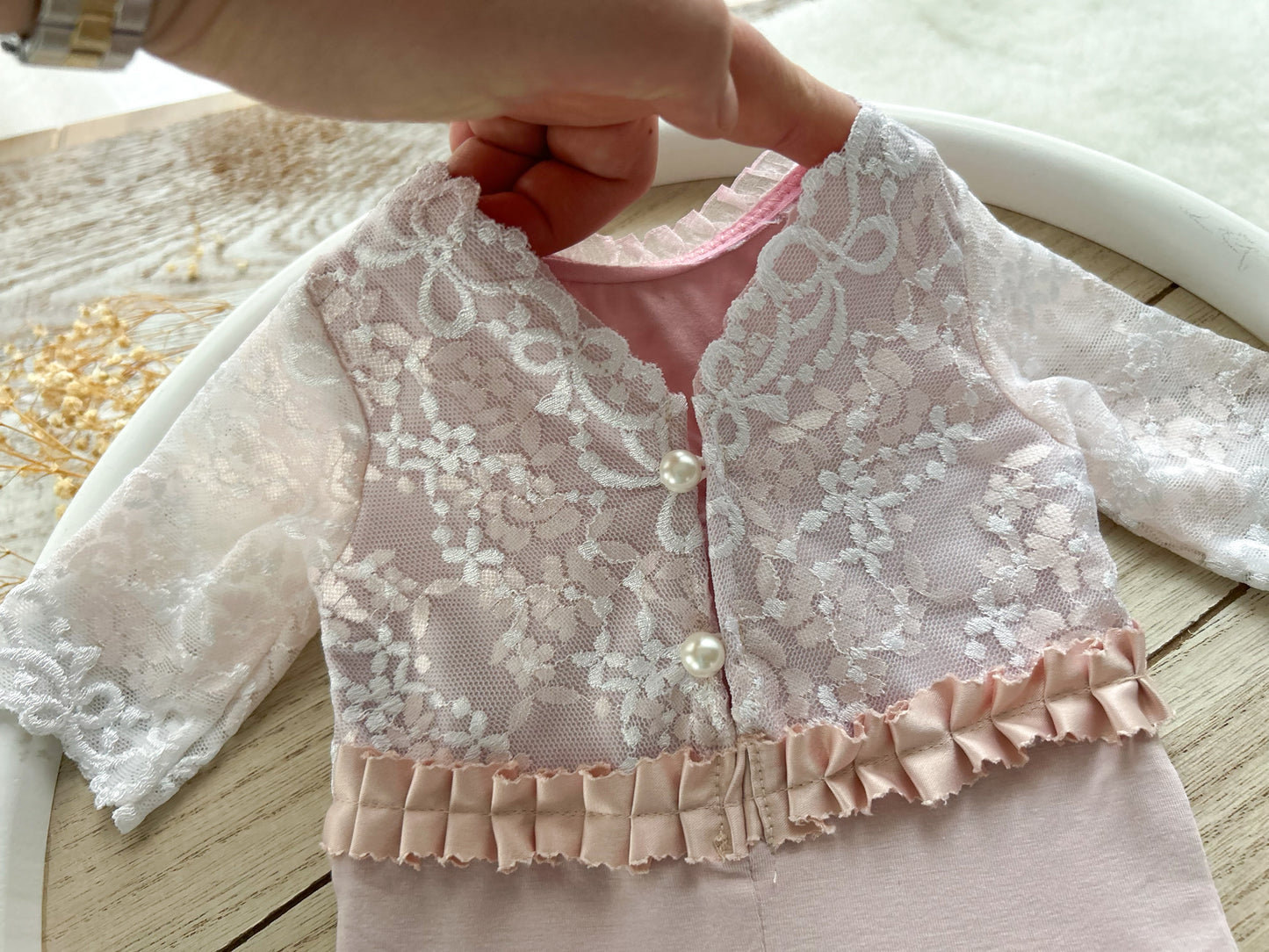 Newborn photography romper for baby girls first photo shoot made of soft jersey fabric and lace in light pink color, with ruffles