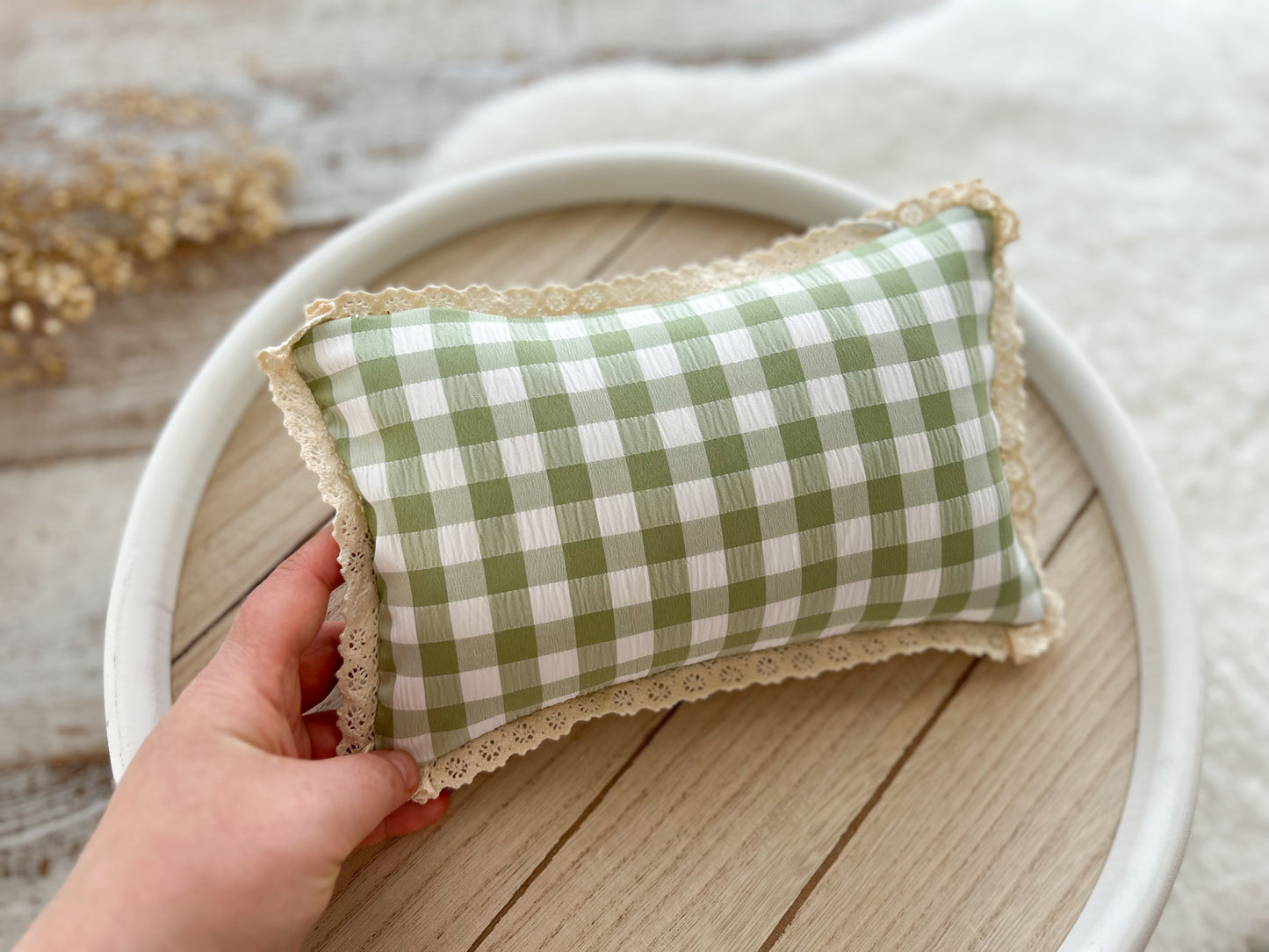Newborn posing pillow in gingham green and ivory fabric with lace trim, vintage rustic look.
