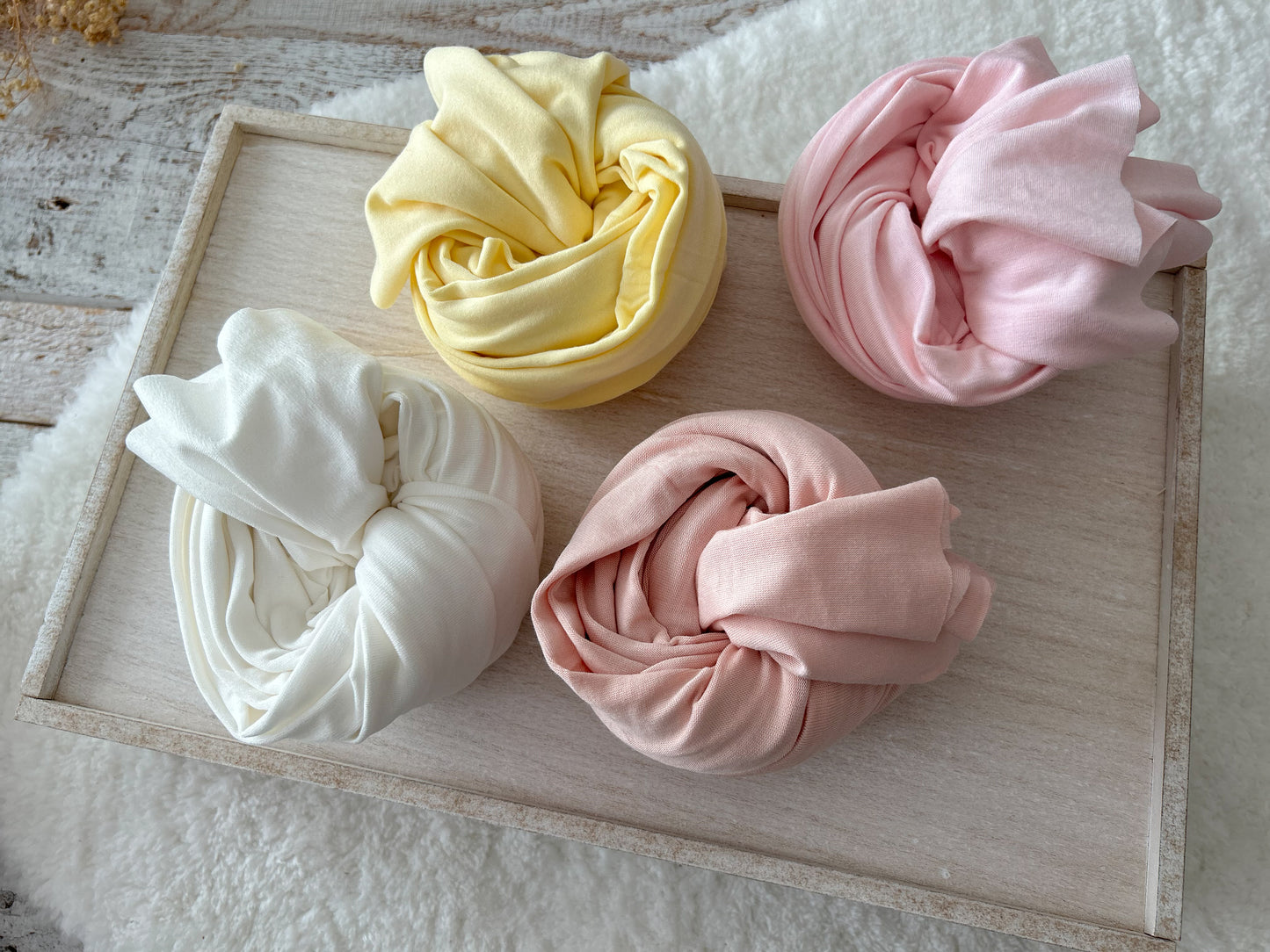 Newborn fabric wraps, stretchy and soft cotton for newborn photography in: ivory, light yellow, light pink, and peach.