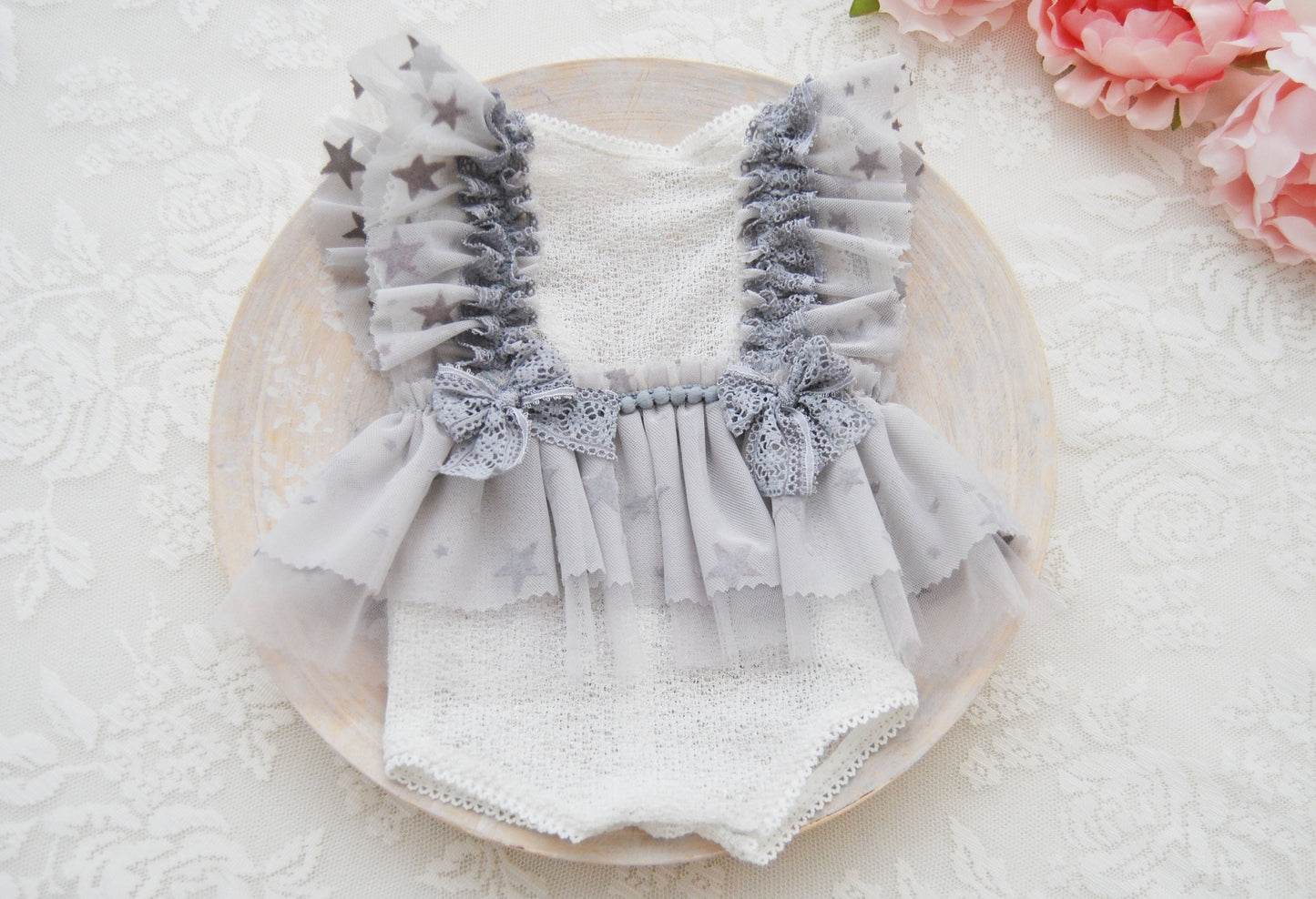 The front of the baby romper, gray color, stars, lace and bows. Perfect for newborn photo sessions