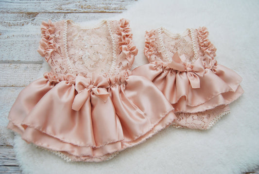 Sitter girl photo shoot outfit for baby girls. This dusty pink romper is made of textured lace for the body part and satin for the ruffles and the rich skirt. It has opened back and a sweet bow.