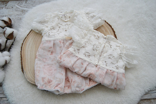 Newborn girl romper for photo shoots, in white and pink shaders. This soft baby outfit with floral pattern is made of muslin fabric and textured lace. It has a puffy design with ruffles sleeves. Perfect as newborn photo prop or baby shower gift.