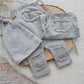 Gray baby pants with patches on a wooden surface