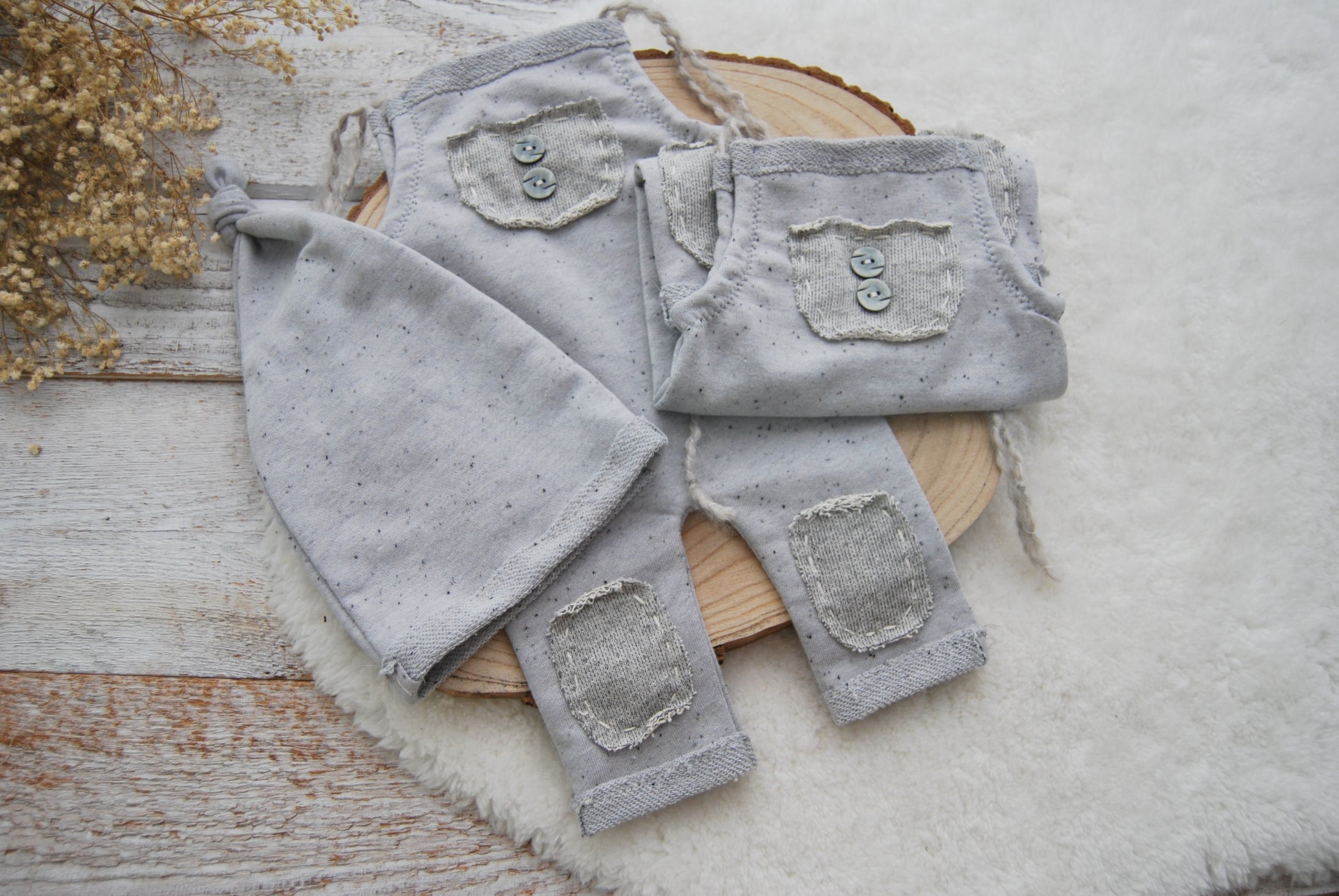 Gray baby pants with patches on a wooden surface