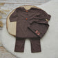 The back of a newborn boy romper with button closure and a newborn beanie