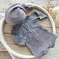 Gray baby outfit with hat on a wooden surface