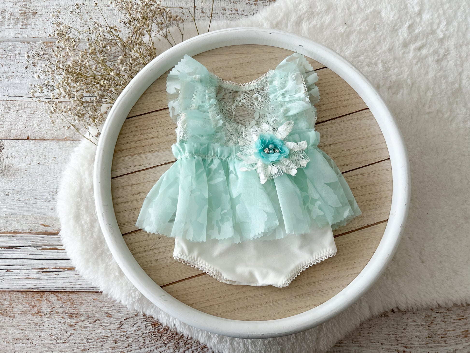 Newborn girl photo outfit in Light mint color floral details on a wooden surface