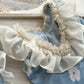 Close up on the back of the romper that has an U shape and is decorated with ruffles and pearl beads.