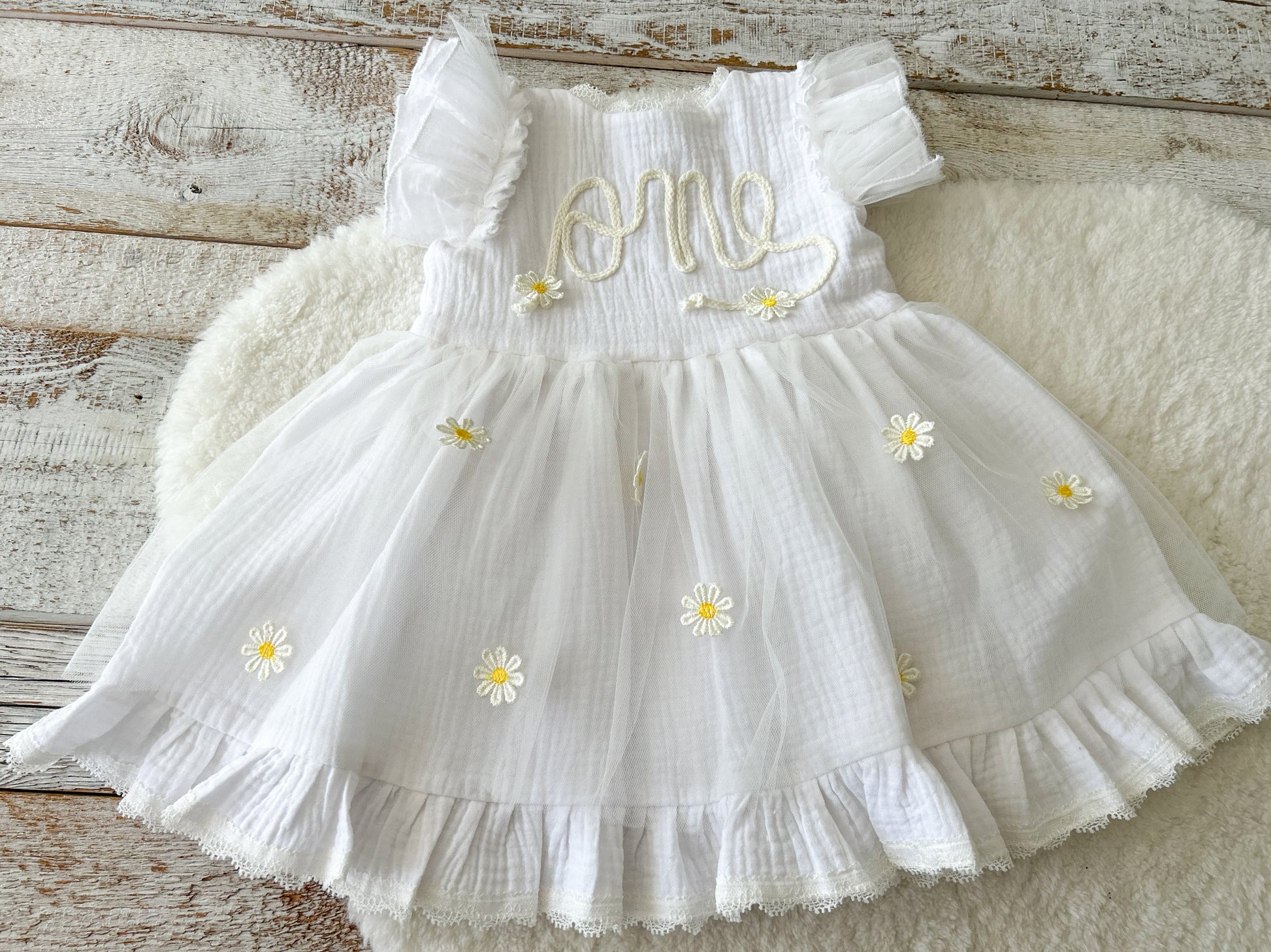 White dress with floral details on a wooden surface