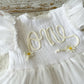White dress with floral embroidery on a wooden surface