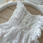 Close-up of embroidered floral lace and pearl bead detail on front panel