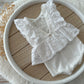 Newborn lace romper made of white lace with floral texture
