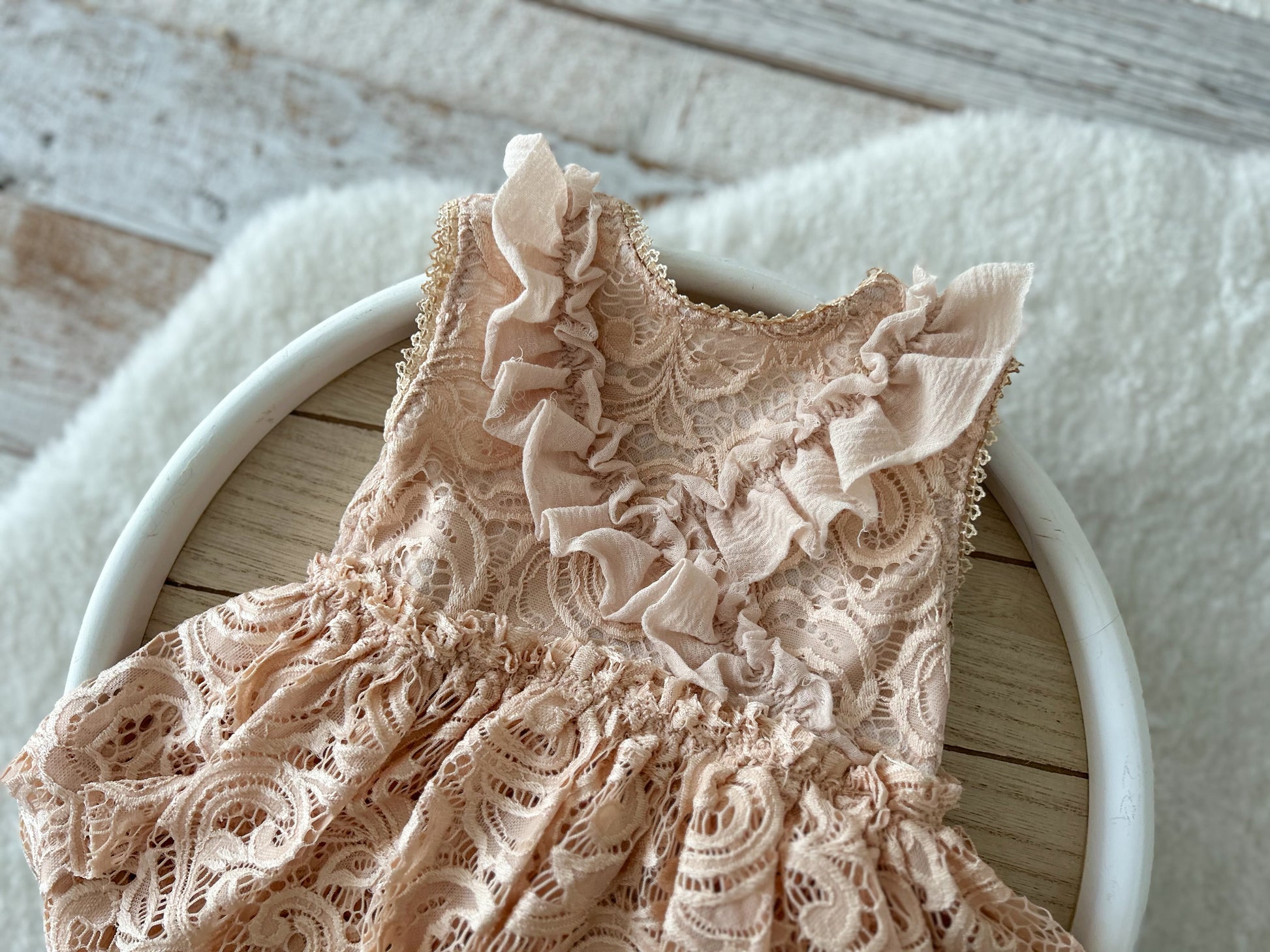 Front view of blush lace baby romper with ruffled skirt for sitter session (6–12 months)