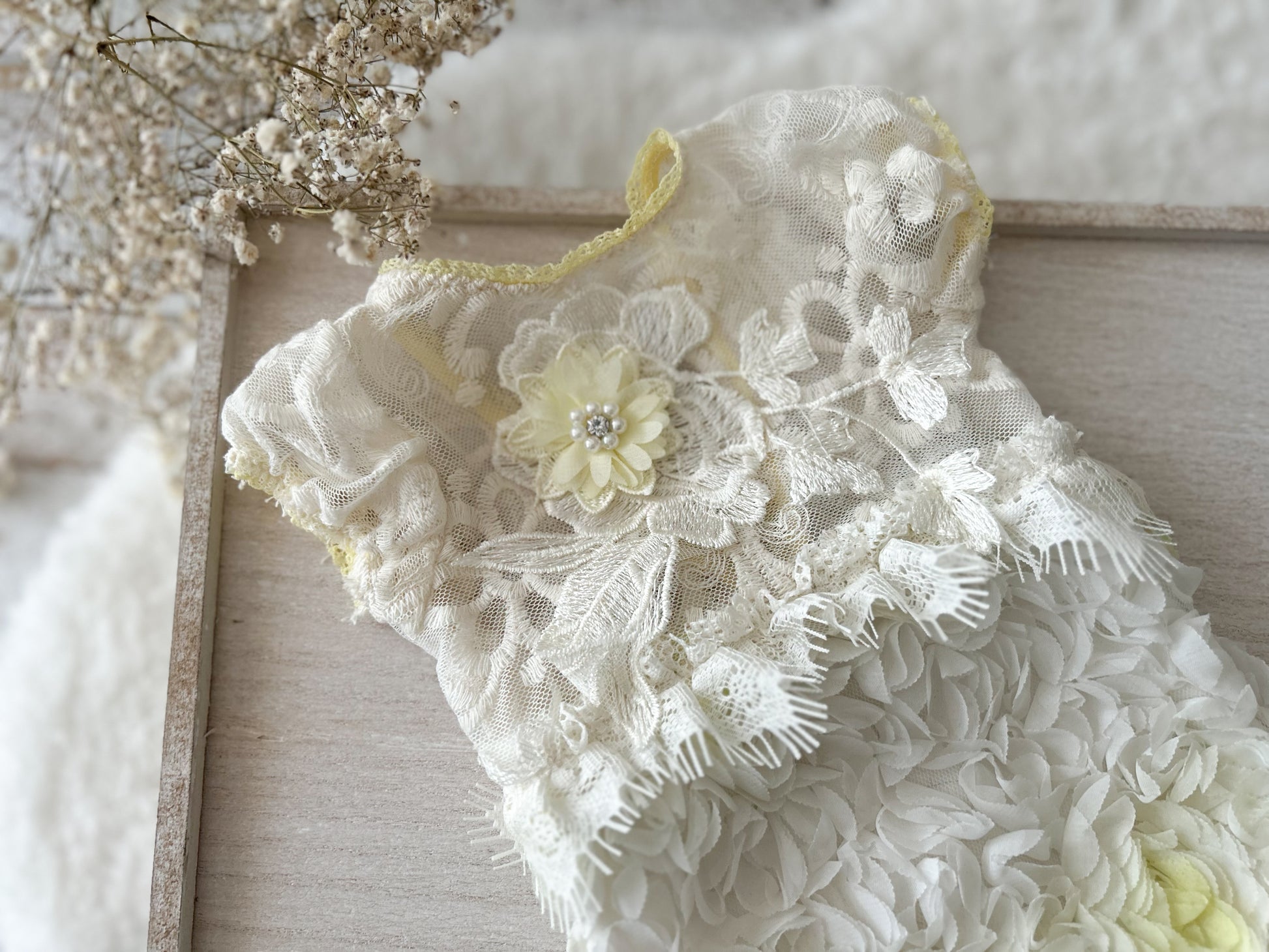 White lace garment with floral details on a wooden surface