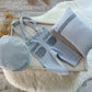 Blue Newborn boy photo outfit that includes suspender pants with pockets, flat cap and posing pillow. 