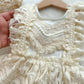 Close-up of a lace dress held by a hand with a blurred background