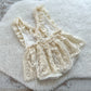 Full view of 6–12 months baby girl romper with ruffles and floral lace skirt, styled for cake smash shoots