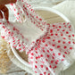 White headband with red heart patterns on a light wooden surface