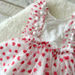 Close up on the white sitter dress with pompoms and red hearts