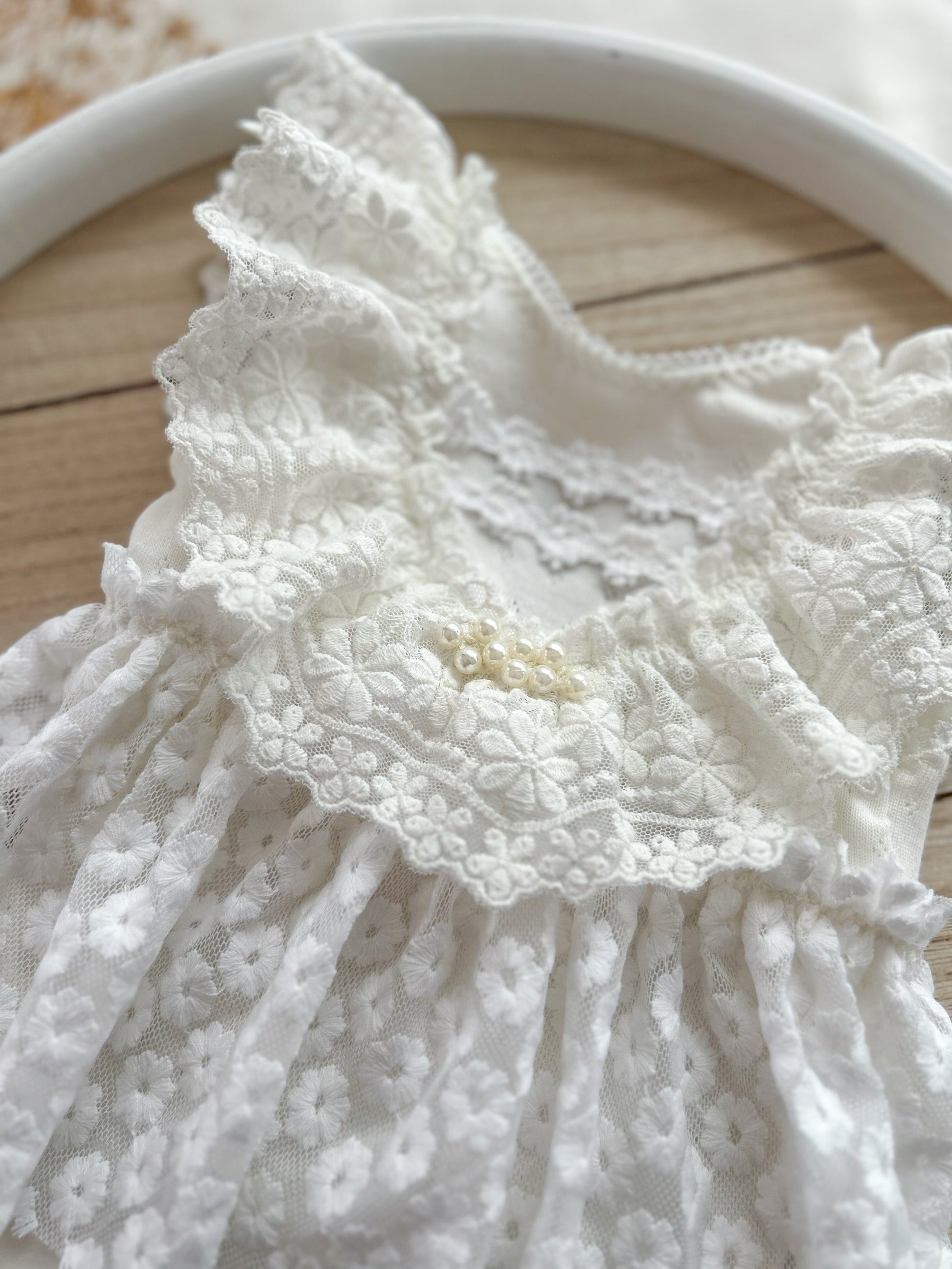 Detailed view of floral lace romper with flutter sleeves